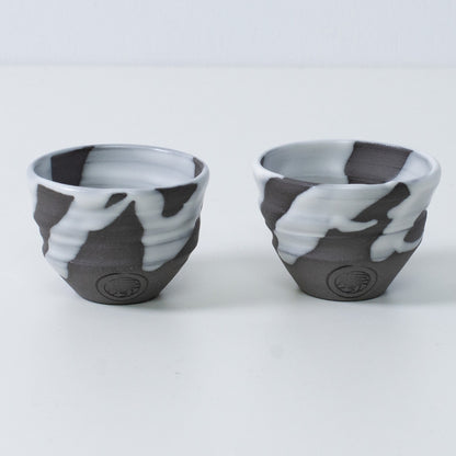 Two Japanese sake cups ochoko "White Flow" pottery from Japan, featuring an engraved artisan seal on the front of each cup.