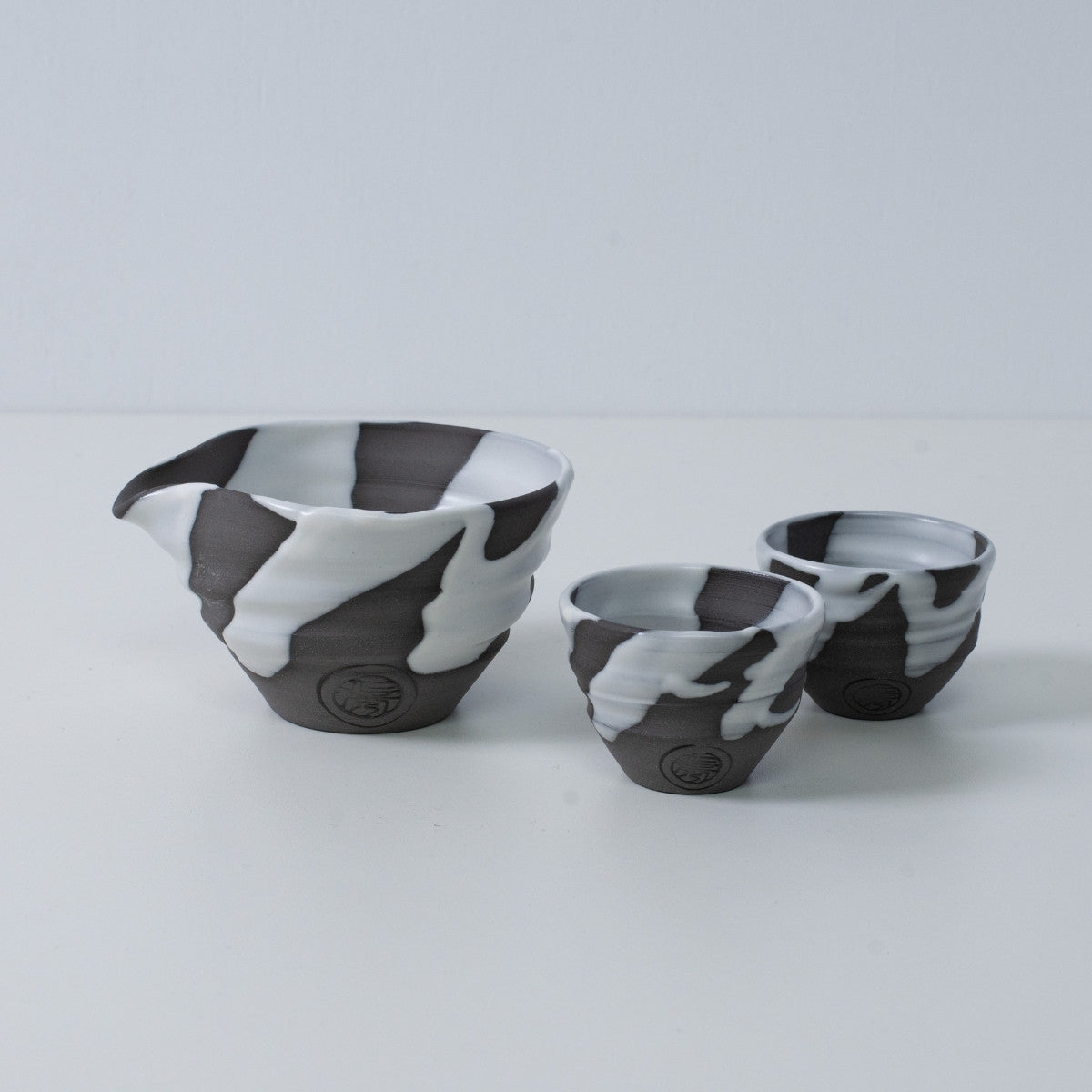 Japanese sake set "White Flow" pottery featuring a katakuchi sake carafe pitcher and two small sake cups, made in Japan.