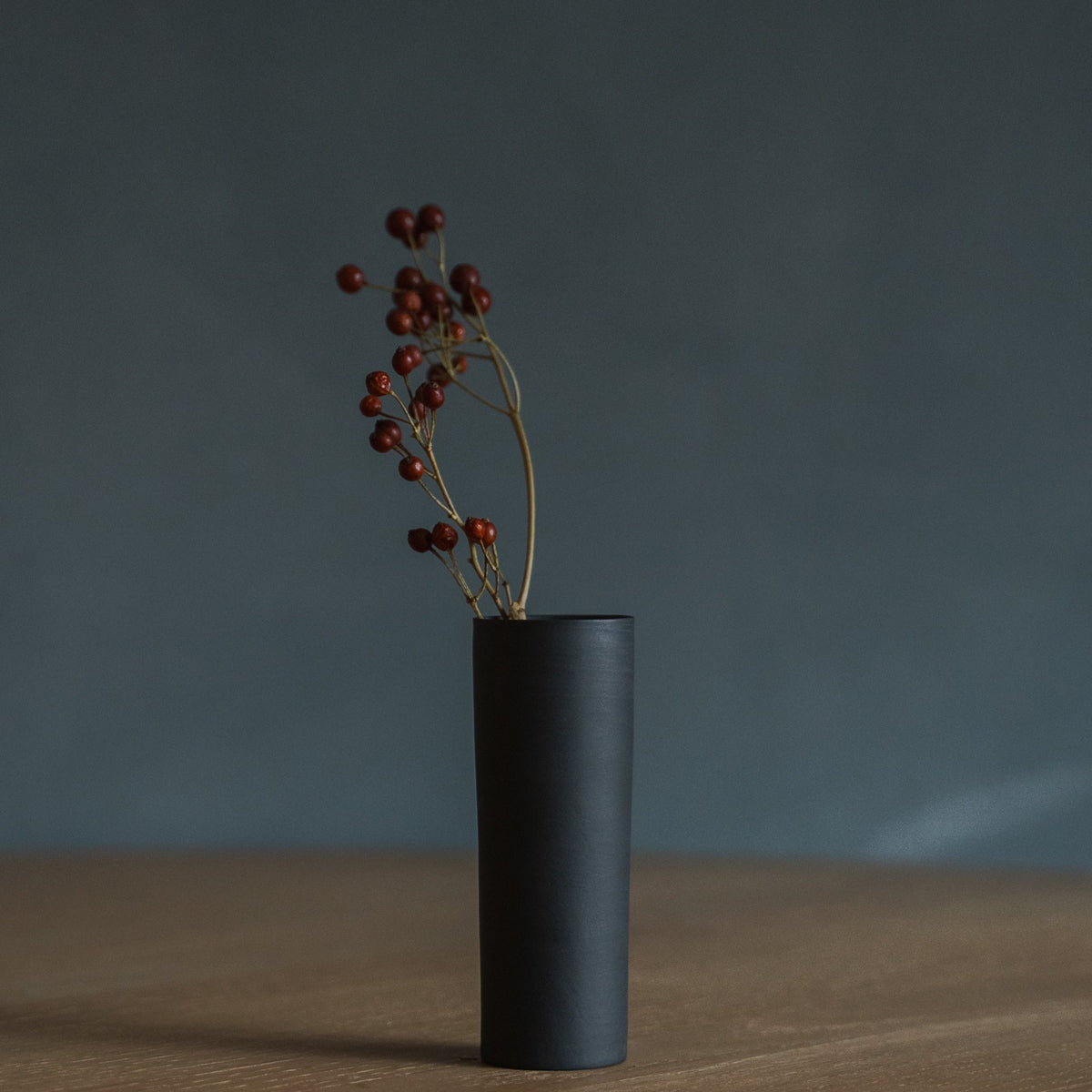 Japanese Single Flower Vase "Cylinder" in black styled in a dining room setting, dining scene view.