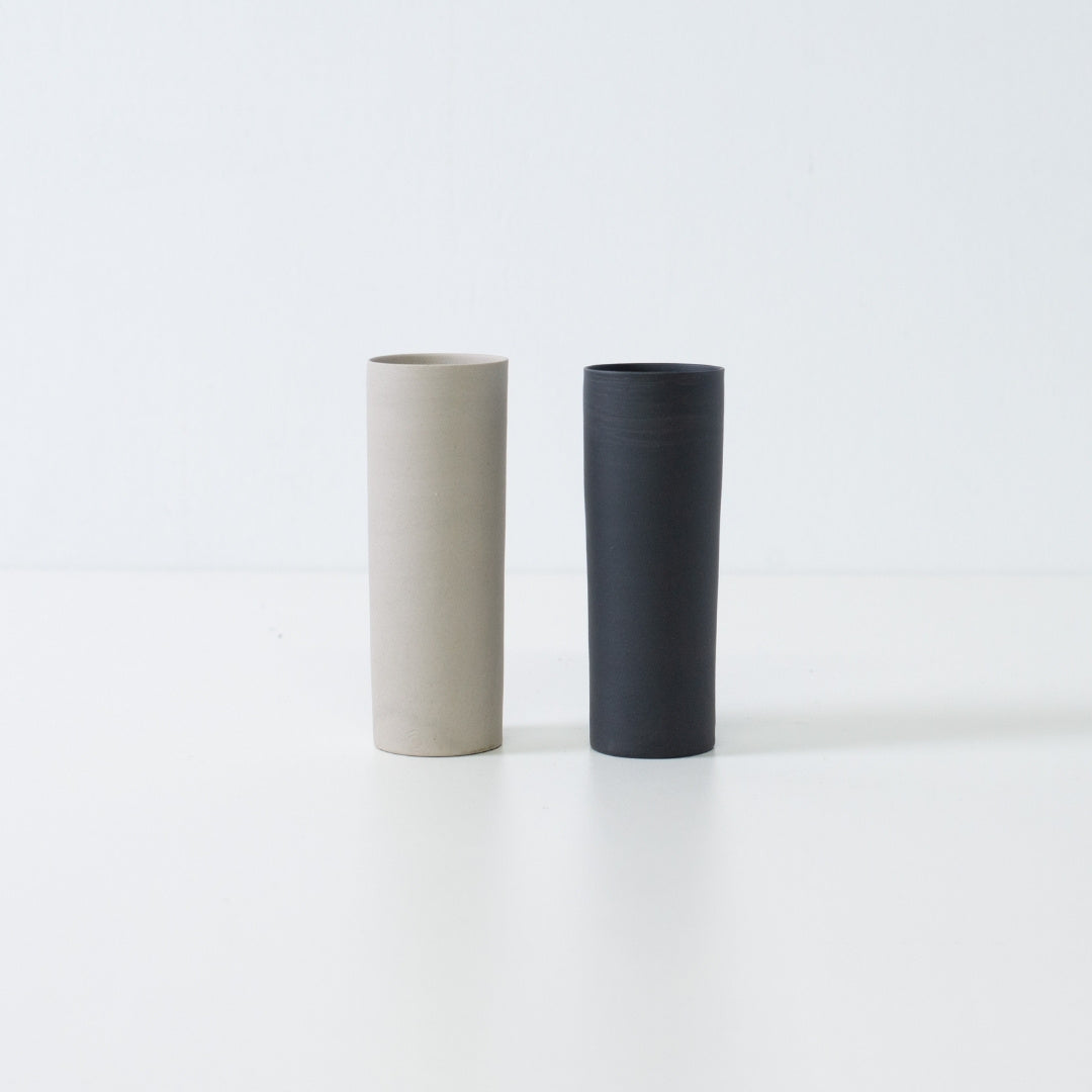 "Een paar zwart-witte Japanse vazen met bloemen, samen staand in een minimalistische zen-opstelling van Banko yaki kunst."