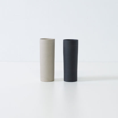 "Een paar zwart-witte Japanse vazen met bloemen, samen staand in een minimalistische zen-opstelling van Banko yaki kunst."