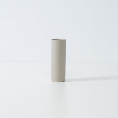 minimalistische witte Japanse vaas met een slanke cilindervorm, handgemaakt voor seizoensgebonden enkele bloemen.
