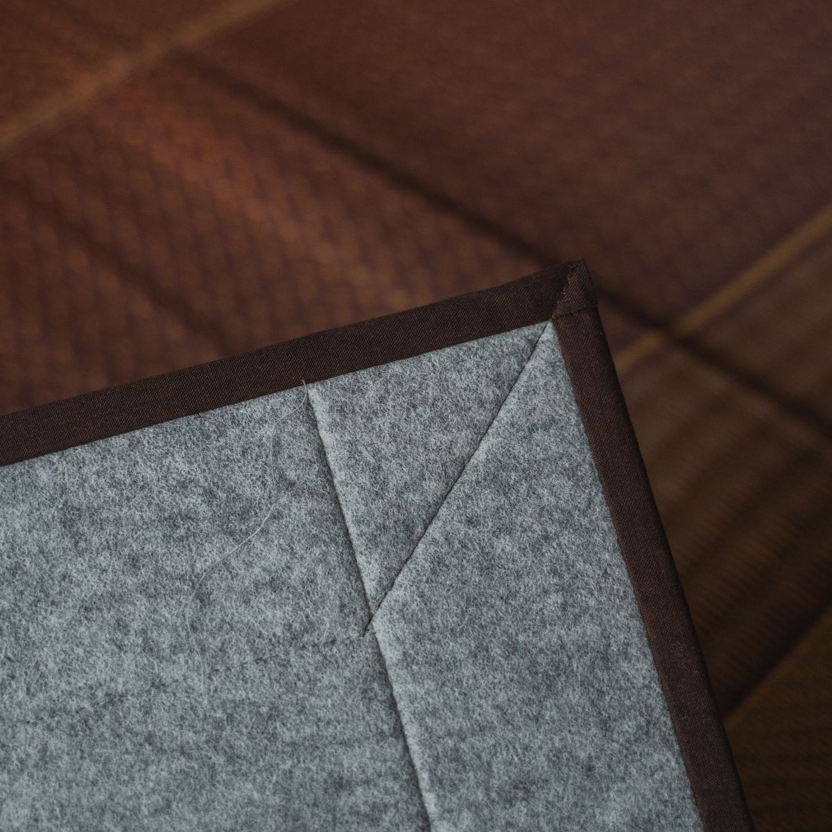 Japanse bordeauxrode tatami vloerkleed met zichtbare non-woven achterkant, voor een vloerveilige basis in moderne kamers.