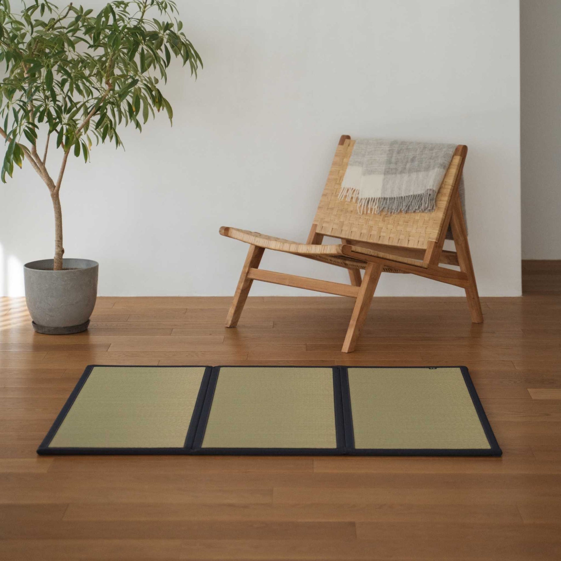 Drieluik van ongeverfde tatami-matten op een houten woonkamervloer voor een glad en natuurlijk zen-decor.