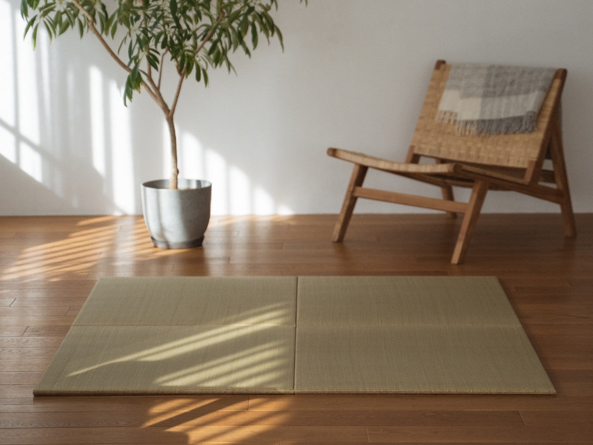 Vier quadratische Tatami-Matten-Paneele, die auf einem Holzboden im Wohnzimmer ausgelegt sind und eine natürliche Zen-Dekorationsecke bilden.