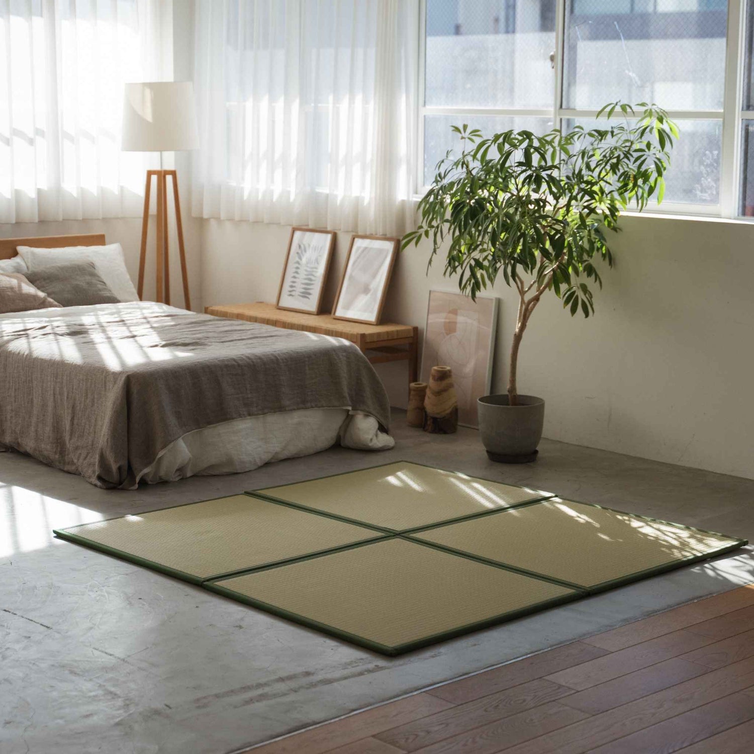 Groene vierkante tatamimatten gerangschikt op een betonnen slaapkamervloer, wat zorgt voor een stijlvolle en vlekbestendige meditatieruimte.