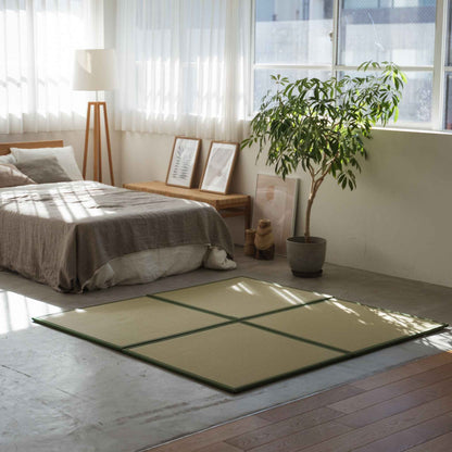 Groene vierkante tatamimatten gerangschikt op een betonnen slaapkamervloer, wat zorgt voor een stijlvolle en vlekbestendige meditatieruimte.