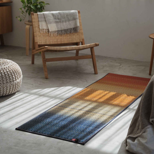 Red tatami yoga mat laid on a concrete living room floor creating a vibrant space for zen decor.