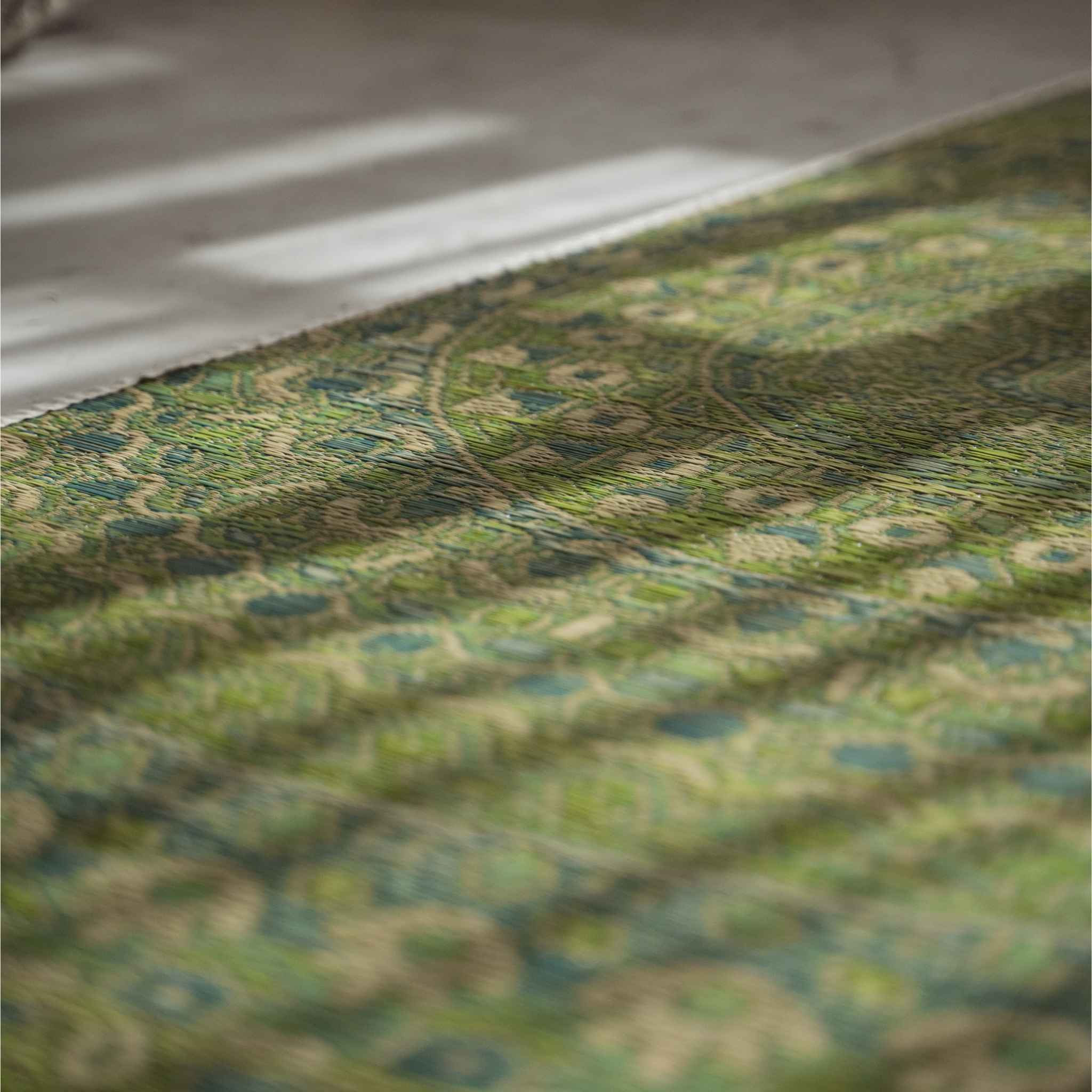 Nahaufnahme des grünen Mandala-Designs, das in eine Tatami-Matte aus Binsengras für Zen-Dekoration eingewebt ist.