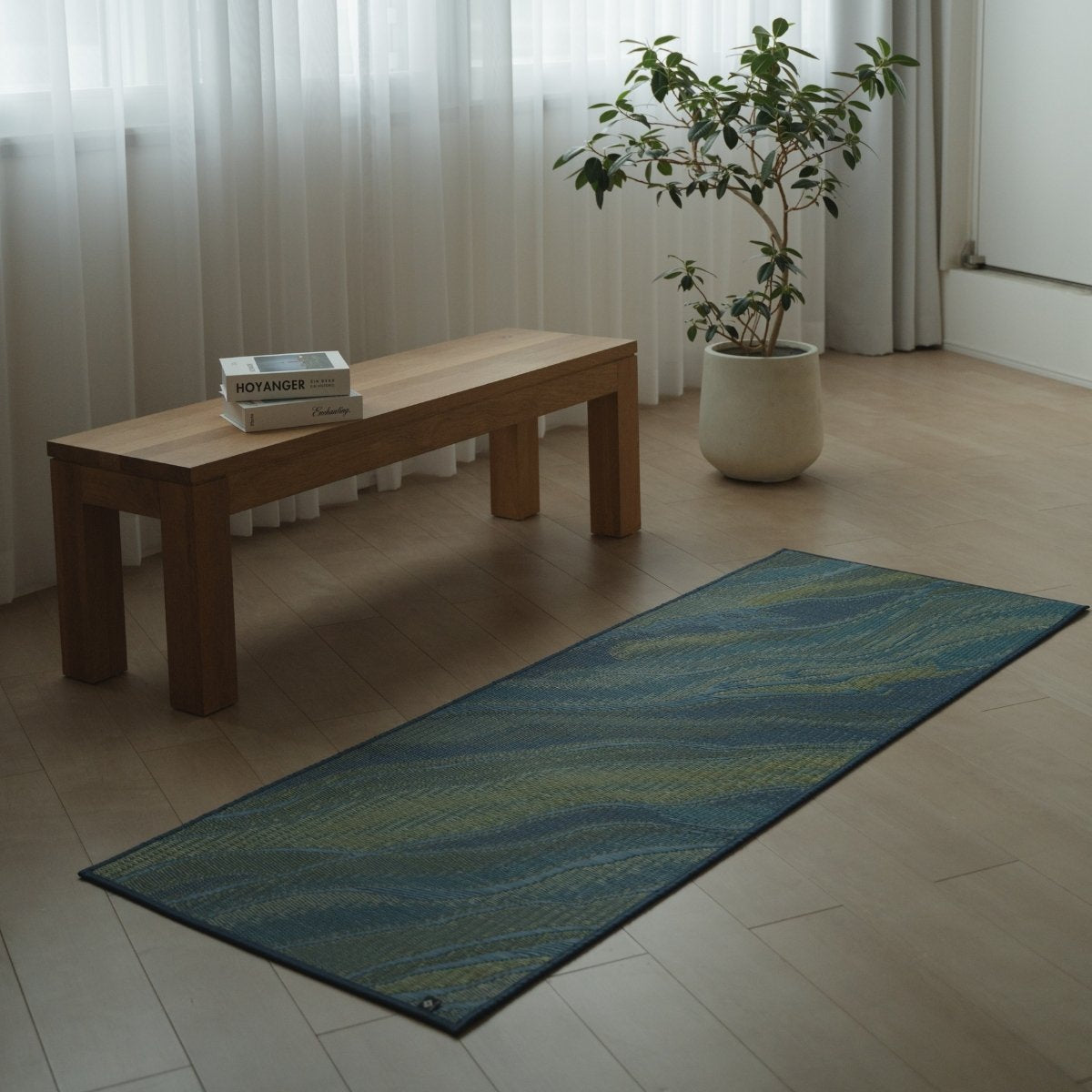 Japanese Tatami Yoga Mattress "Marble" Blue placed on a wooden floor in a minimalist living room for home yoga practice.