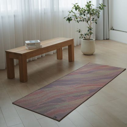 Japanische Tatami-Yogamatte „Marble“ in Rosa, ausgelegt auf einem hellen Holzboden in einem minimalistischen Wohnzimmer für die Meditation zu Hause.