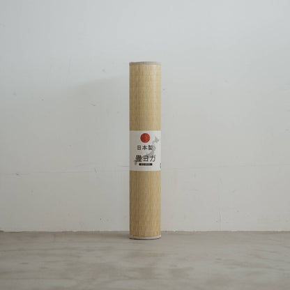 Aufrecht gerollte Tatami-Matte mit gewebtem grünem Muster aus Binsen für minimalistische japanische Dekoration.