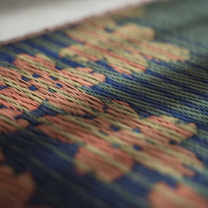 Schuine weergave van een tatami yogamat met een geweven kersenbloesemontwerp voor prachtige Japanse decoratie.
