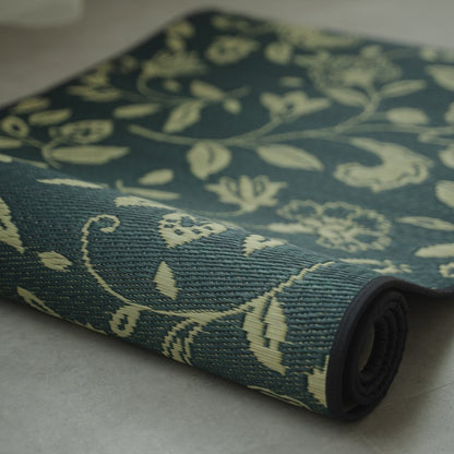 Japanese Tatami Yoga Mattress "Sarasa" Navy partially rolled on a grey floor, showcasing the natural rush grass weave and pattern.
