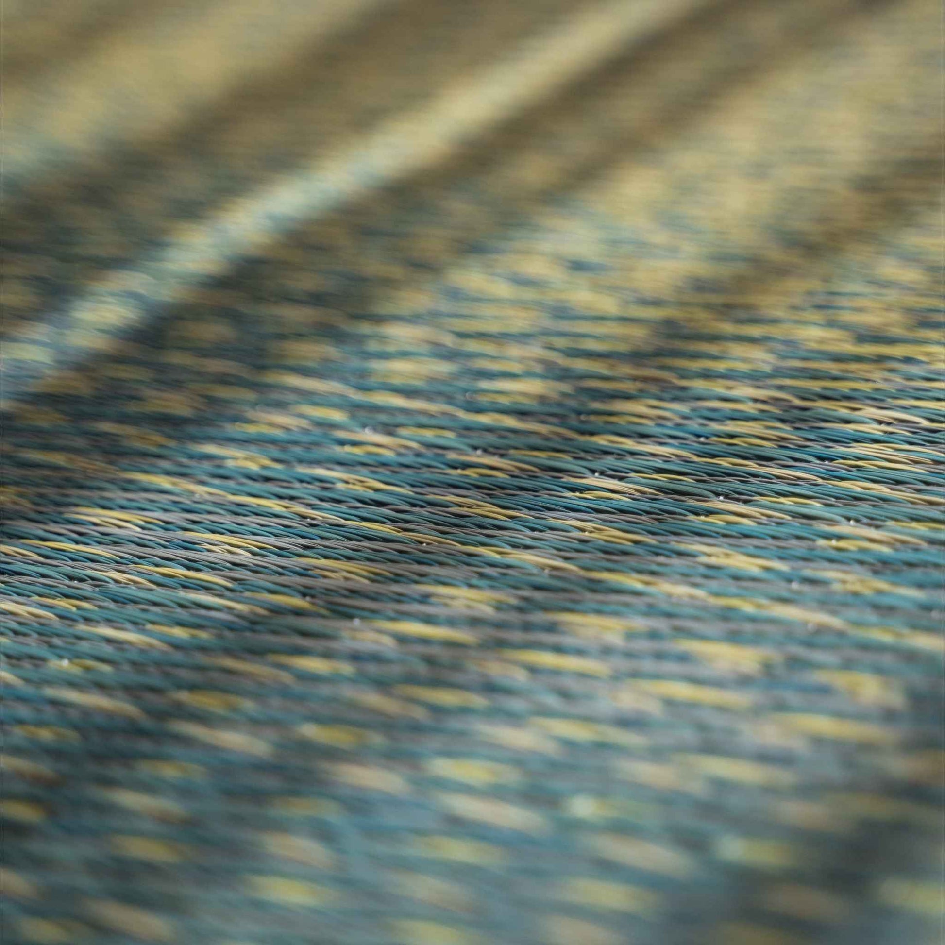 Nahaufnahme von geflochtenem Schilfgras auf einer blauen Tatami-Matte mit Himmels- und Meeres-Farbverlauf.