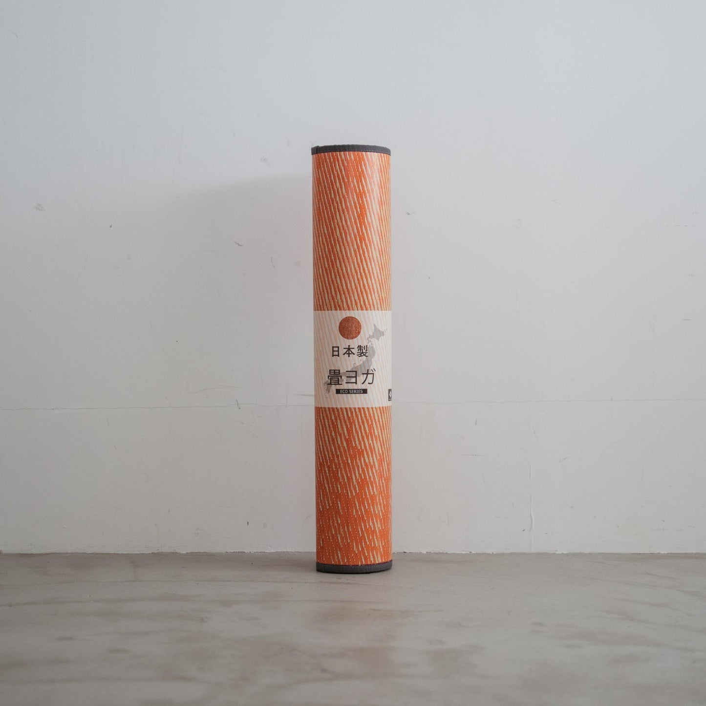 Aufgerollte rote Tatami-Yogamatte, die an einer Wand steht und ihr tragbares Design sowie ihren japanischen Ursprung hervorhebt.