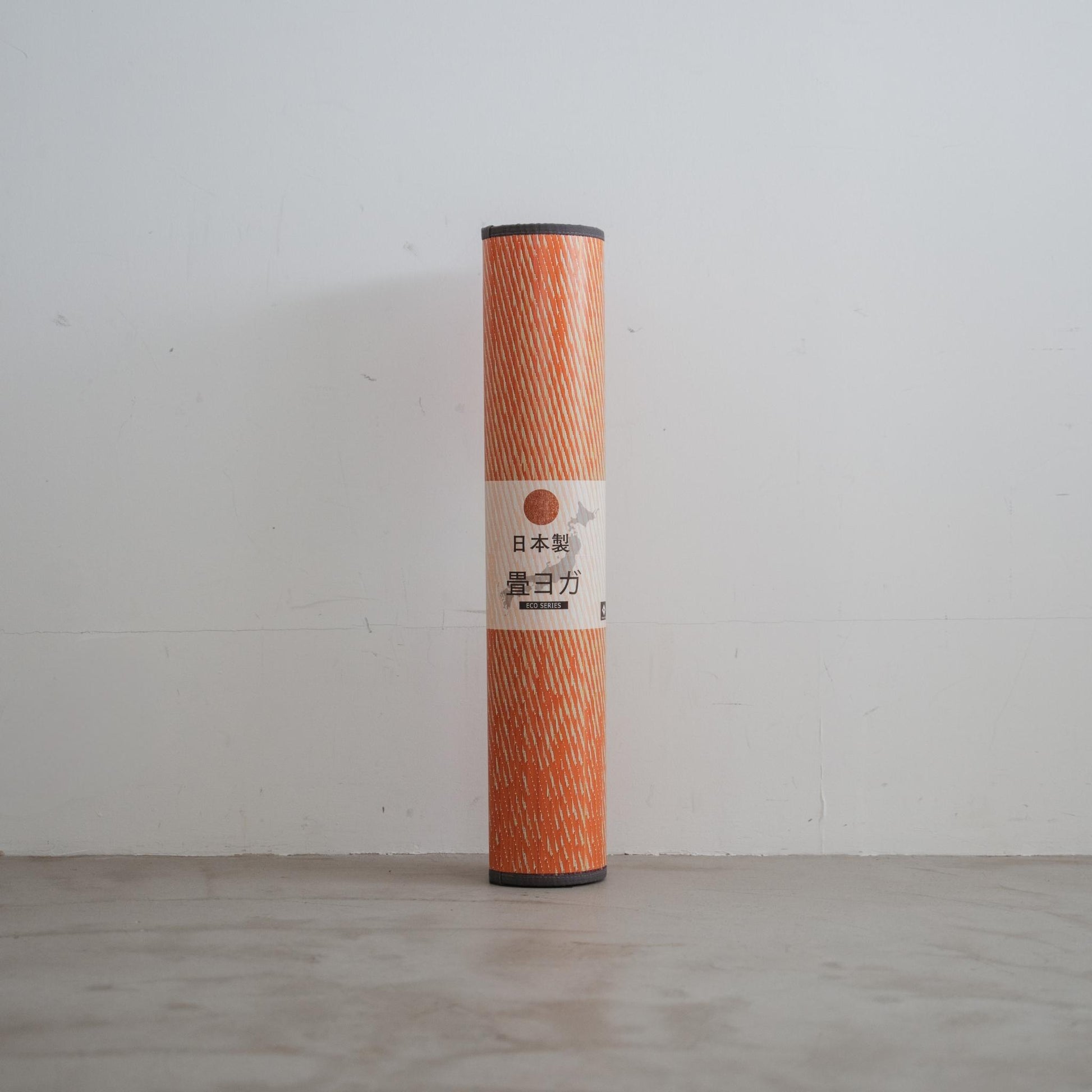 Aufgerollte rote Tatami-Yogamatte, die an einer Wand steht und ihr tragbares Design sowie ihren japanischen Ursprung hervorhebt.