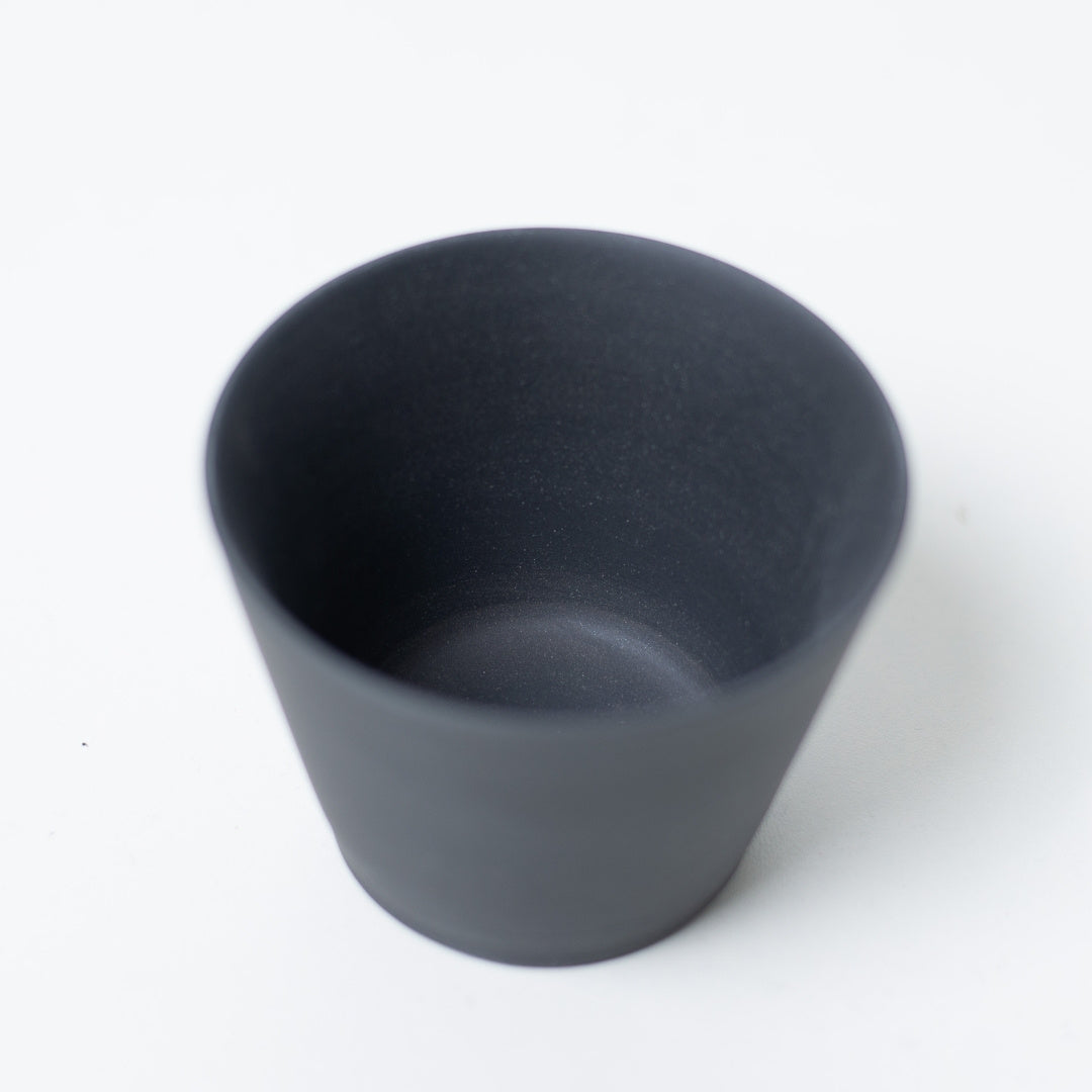 Vue intérieure d'une tasse à thé japonaise noire non vernissée montrant la texture lisse de l'argile sombre du chawan ensui