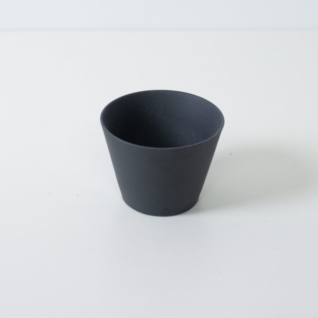 Vue en plongée d'une tasse à thé japonaise ensui noire, montrant le bord fin et la forme conique en grès