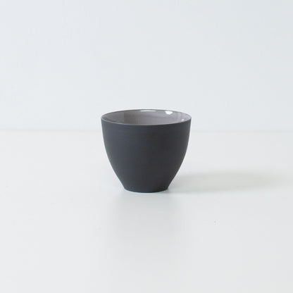 Sidevisning af matsorte japanske tekopper f-form chawan stående på hvid overflade med moderne banko-keramik silhuet