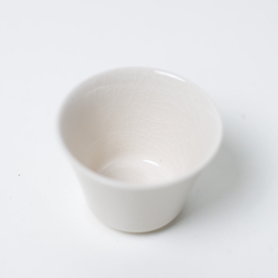 Indvendigt billede af en hvid kodai japansk tekop, der fremhæver det sarte krakelerede glasurmønster på porcelænet