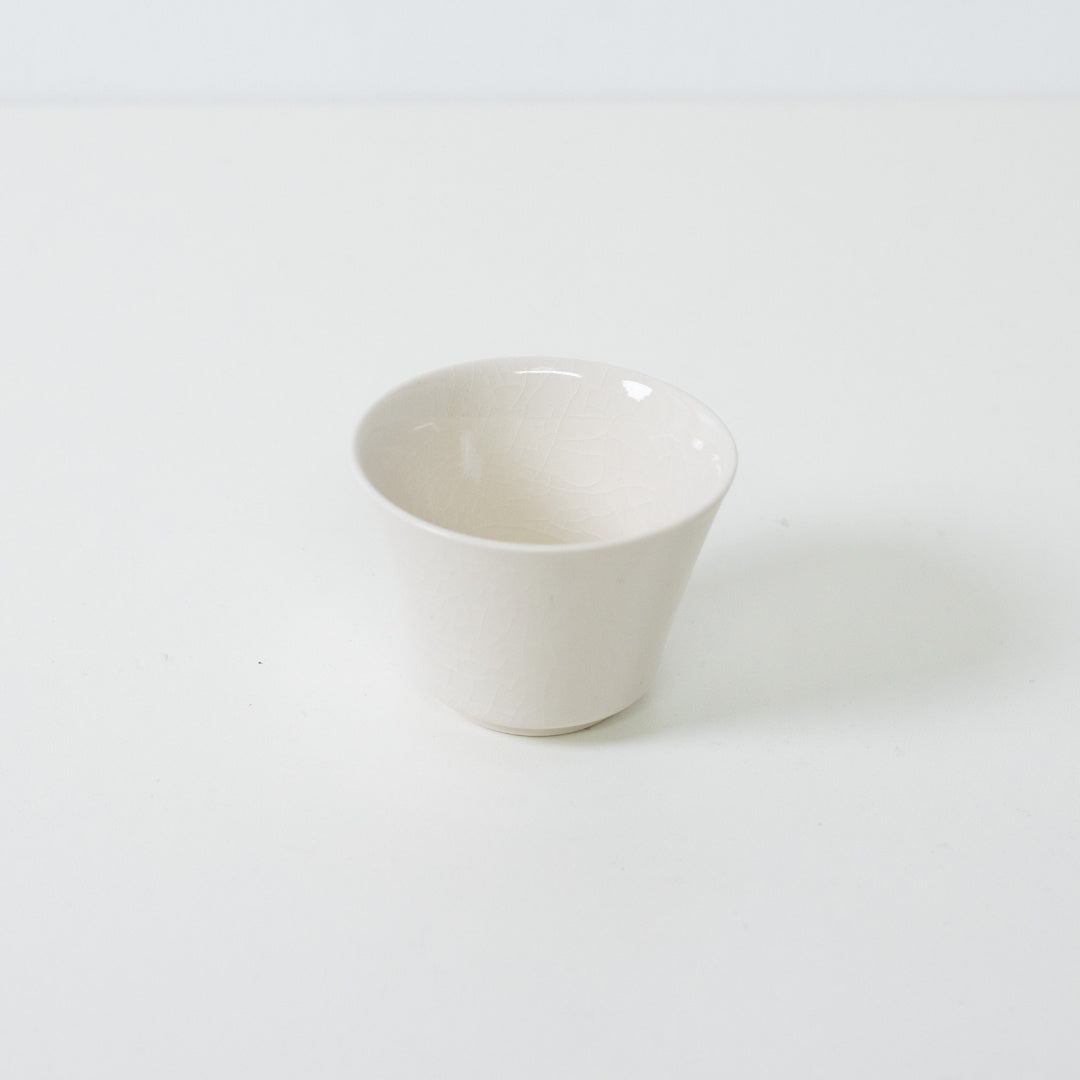 Hvid kodai japansk tekop med en traditionel høj fod og en blank krakeleret glasurfinish.