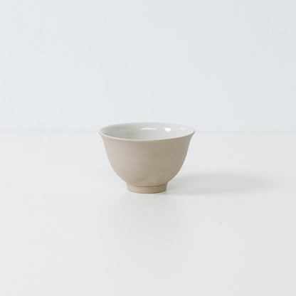 Profilvisning af en enkelt beige kumidashi japansk tekop med en mat stentekstur