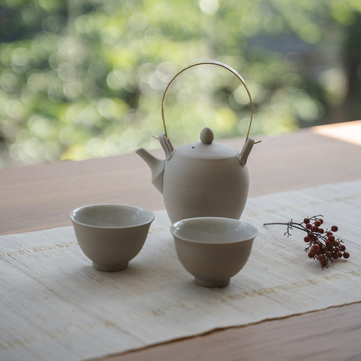 Service à thé japonais blanc "Donguri" avec tasses Kumidashi sur une table ensoleillée pour les amateurs de thé profitant d'un moment paisible.
