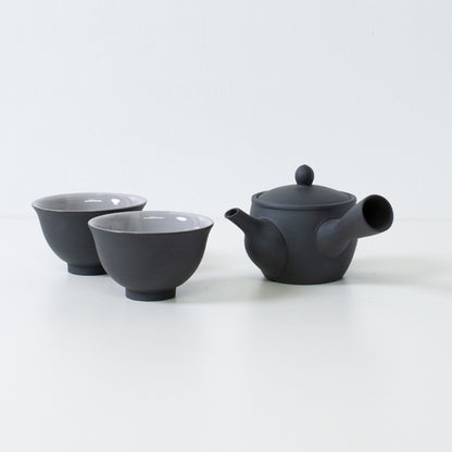 Sort japansk tesæt med fuyo kyusu tekande og kumidashi kopper arrangeret på hvid overflade til servering.