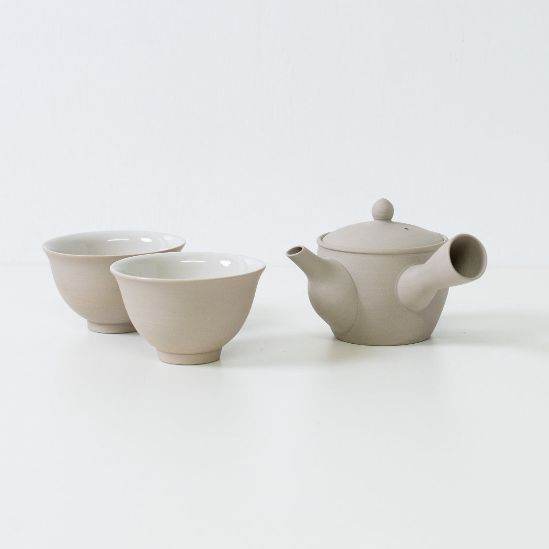 Minimalistisk japansk tesæt med en fuyo kyusu tekande og to kumidashi kopper på et hvidt bord