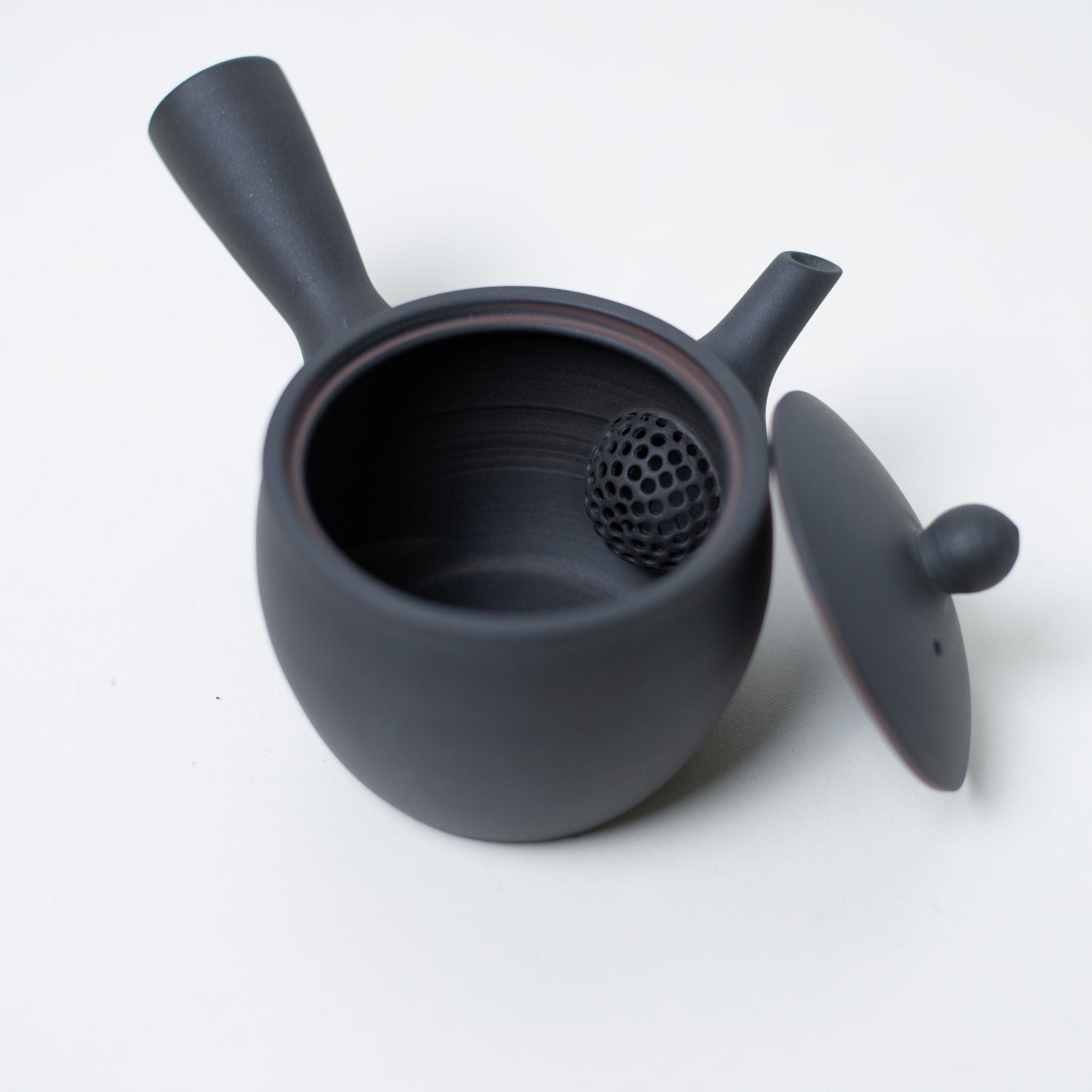Åben japansk tekande, kig ind i den keramiske mesh-si og låget på den sorte kyusu-tekande