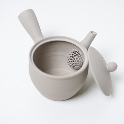 Åben japansk tekande, der kigger ind på den keramiske mesh-si og låget på den hvide kyusu-tekande