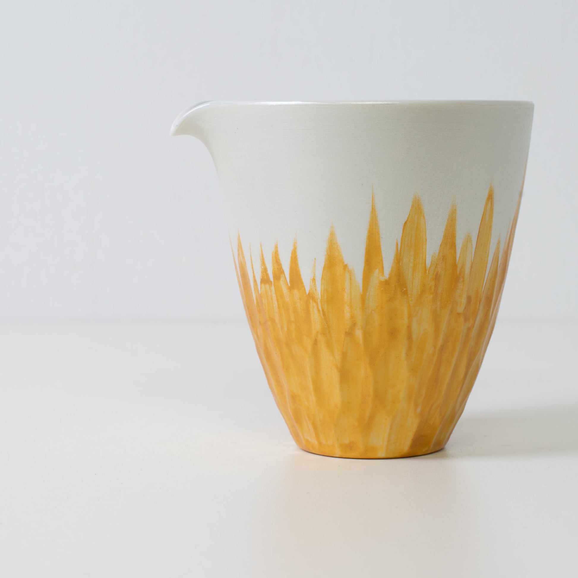 Guldfarvet blomstret sake-karaffel i hvidt porcelæn – Nærbillede af en japansk sake-karaffel med guldfarvede blomsterdetaljer