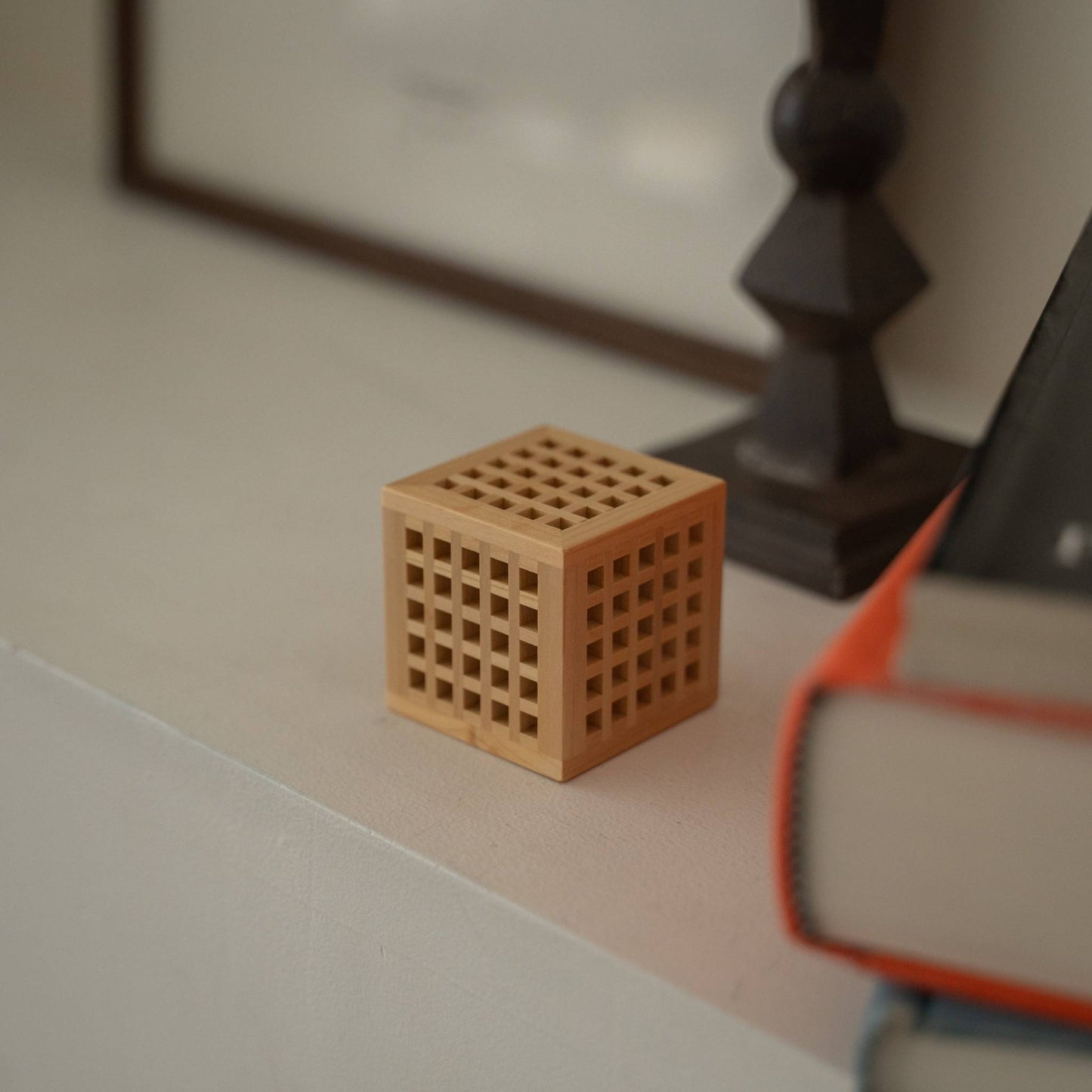 Japanische Holz-Mini-Lampe „Hotaru“ auf einem weißen Konsolentisch, als minimalistische japanische Akzentlampe für Japandi-Dekoration.