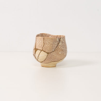 hvid kintsugi matcha-skål hviler ved siden af en trækasse, der repræsenterer smuk wabi sabi-kunst og modstandsdygtig keramikunst