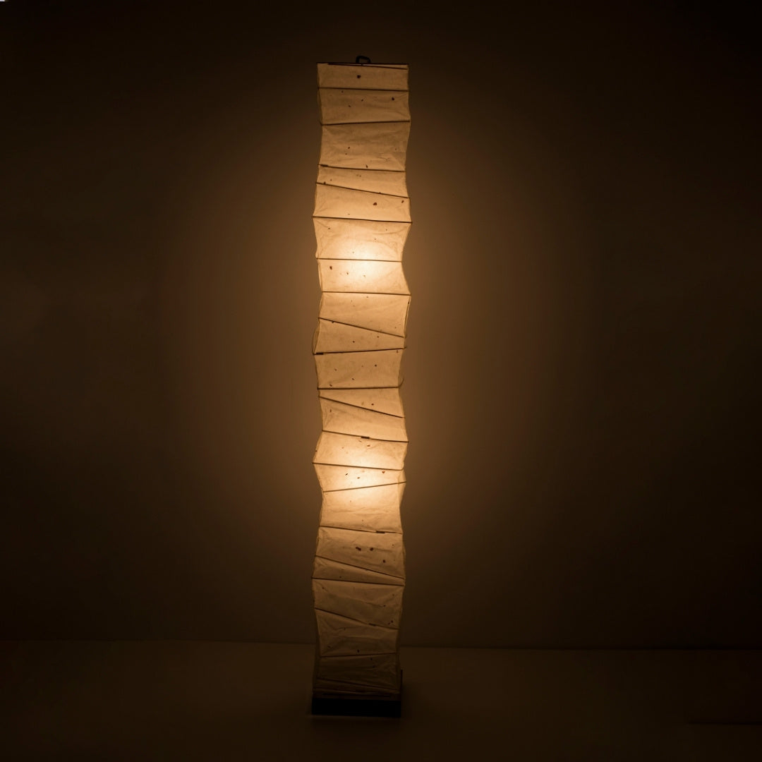 Lampadaire haut en papier washi japonais diffusant une lumière chaude.