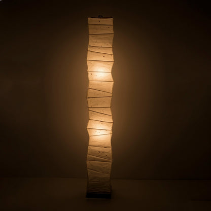 Lampadaire haut en papier washi japonais diffusant une lumière chaude.