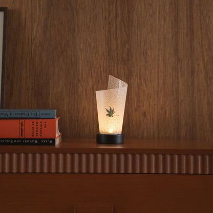 "Lampe de table japonaise en papier "Maki" avec motif de feuille d'érable Momiji projetant une douce lumière vers le haut comme lampe d'ambiance sur une console de style mid-century modern."