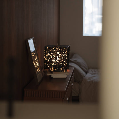 "Cube lumineux en papier japonais Me Look 03 servant de lumière d'appoint sur une console en bois avec décoration."