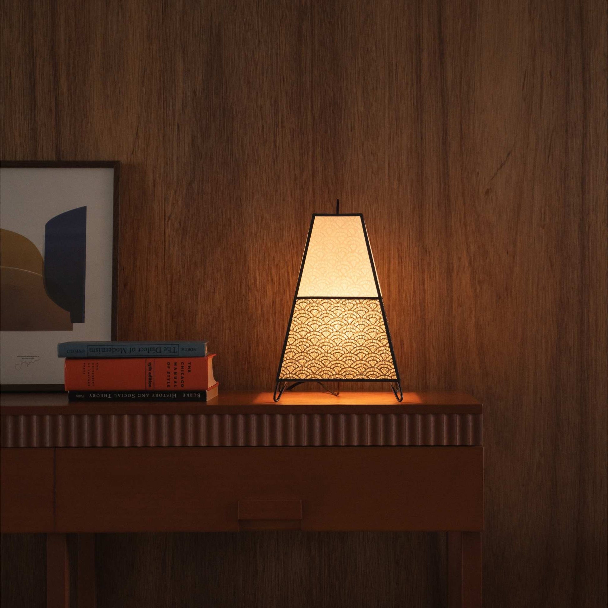Glowlamp van Japans papier KURA klein, rustend op een mid-century modern houten console tafel als een gezellige accentlamp.