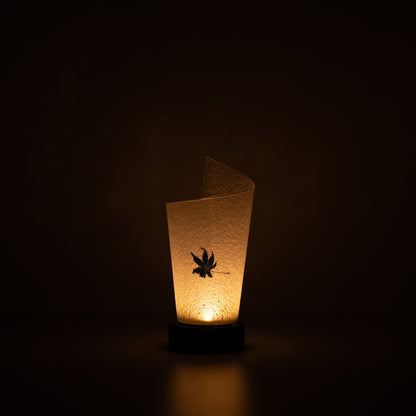"Lampe de table japonaise en papier « Maki » feuille d'érable, blanc, papier Mino Washi - lampe en papier allumée projetant une lueur chaleureuse avec des paillettes rustiques visibles."