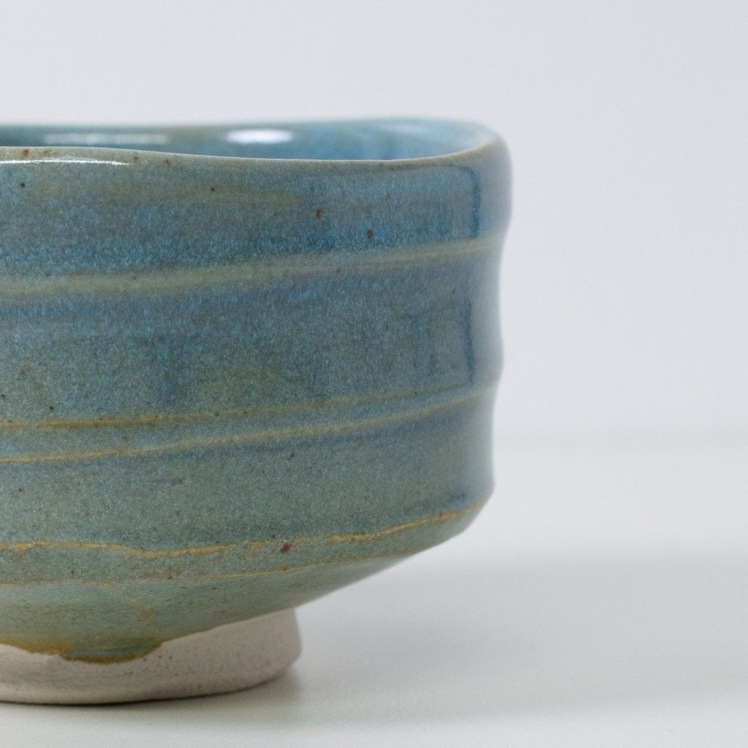 Tæt på detalje af "Summer Sky" matcha-skål, der viser den gennemsigtige blå glasur, som afslører varme, jordbrune lerstriber.