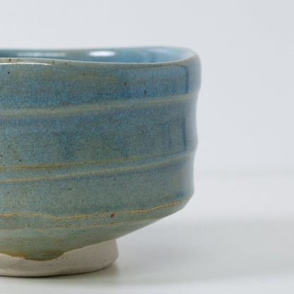 Tæt på detalje af "Summer Sky" matcha-skål, der viser den gennemsigtige blå glasur, som afslører varme, jordbrune lerstriber.