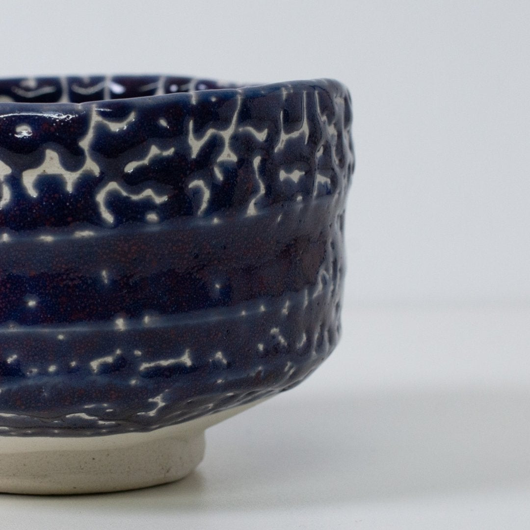 Detalje af Kairagi (krybende glasur) tekstur på en midnatsblå matcha chawan skål, der fremhæver de unikke wabi sabi revner og keramik håndværk.
