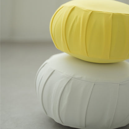 Coussin de méditation zafu japonais jaune mimosa et blanc clair de lune, disposé dans une pièce lumineuse pour la pleine conscience quotidienne.
