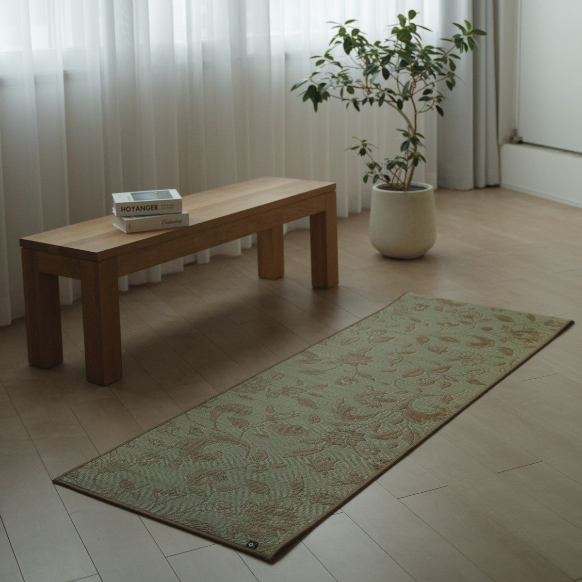 Japanese Tatami Yoga Mattress "Sarasa" Beige with botanical pattern placed on a wooden floor in a minimalist living room for home practice.