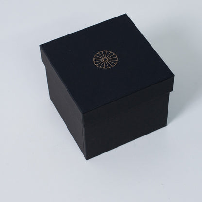 Closed black square Ninshu's gift box for Japanese pottery, featuring a gold imperial chrysanthemum crest on the lid.
