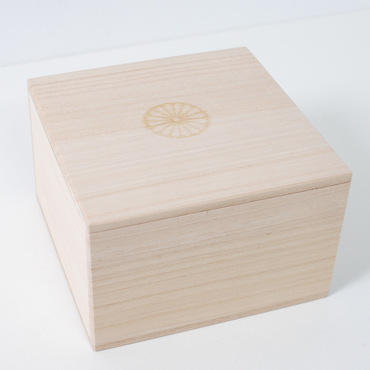 Closed square Ninshu's wooden gift box for Japanese matcha bowl pottery, featuring a branded chrysanthemum crest on the center of the lid.