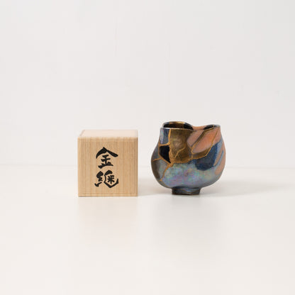 iriserende kintsugi matcha-skål står ved siden af en gaveæske af paulownia-træ, der repræsenterer smuk wabi sabi keramikunst