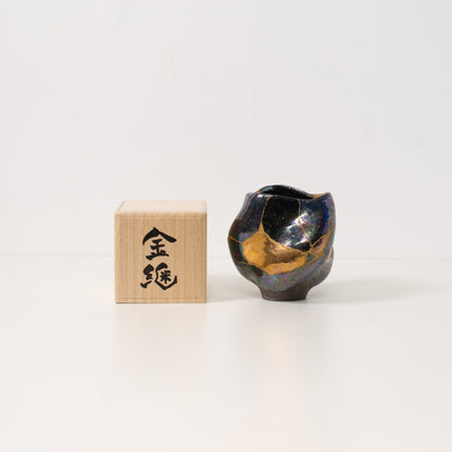 Een iriserende kintsugi matchakom staat naast een houten Japanse geschenkdoos, klaar om te worden gegeven als een uniek kunstwerk